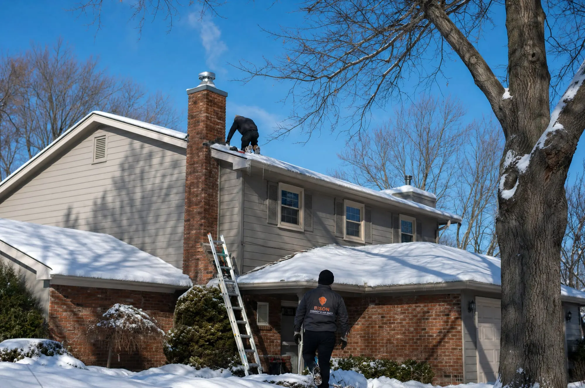 Capped brick chimney on a snowy roof
